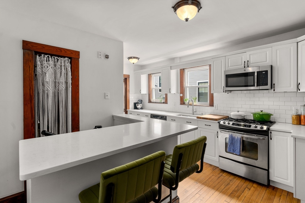 18 Park Road, Unit 1 Belmont, MA 02478 - Photo 19 of 36 a kitchen with stainless steel appliances a stove microwave and sink