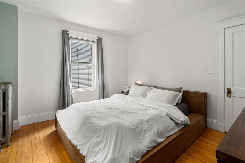 18 Park Road, Unit 1 Belmont, MA 02478 - Photo 27 of 36 a bedroom with a bed and wooden floor