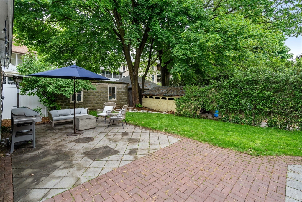 18 Park Road, Unit 1 Belmont, MA 02478 - Photo 34 of 36 a view of a patio with a table and chairs under an umbrella