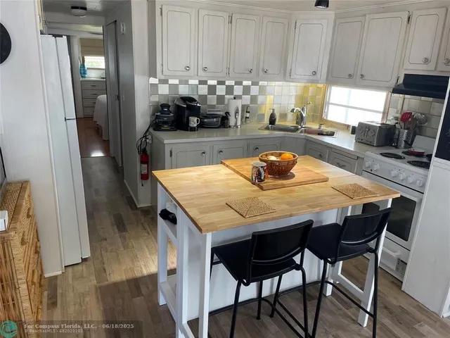 a kitchen with granite countertop a table chairs sink and cabinets