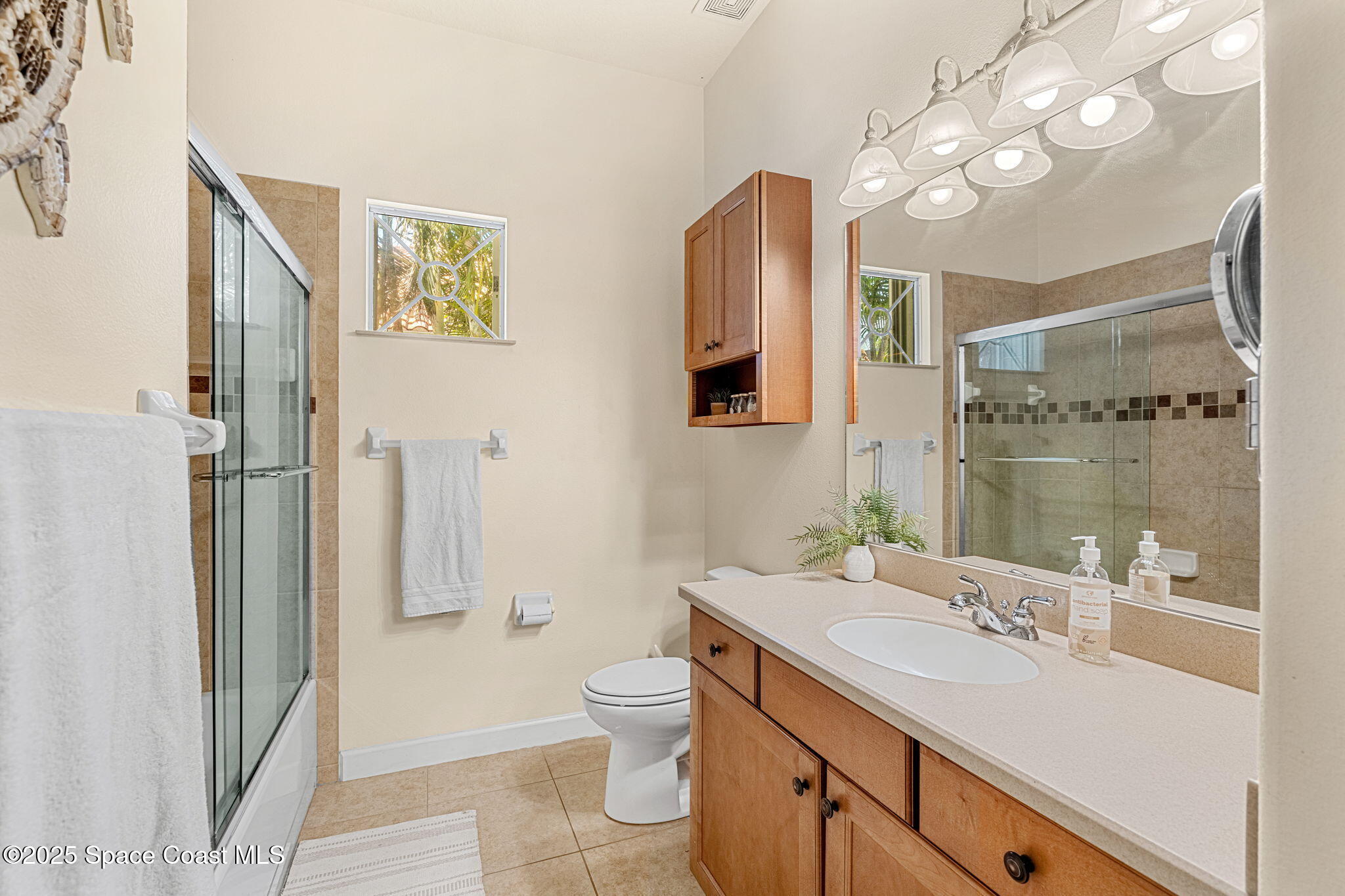231 Loggerhead Drive Melbourne Beach, FL 32951 - Photo 20 of 47 a bathroom with a sink a toilet a large mirror and shower