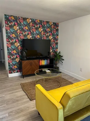 a view of an empty room with wooden floor and closet
