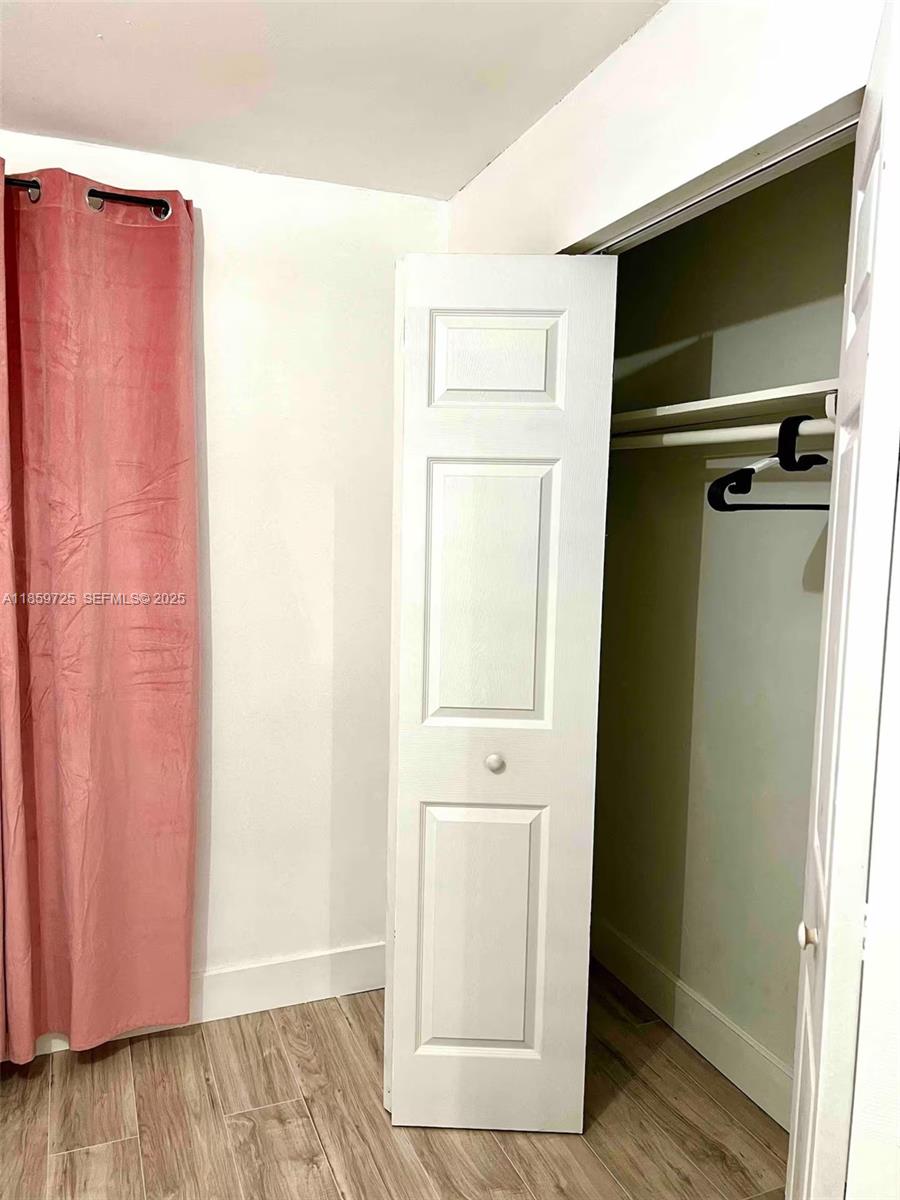 2701 Northwest 24th Court, Unit R Miami, FL 33142 - Photo 14 of 20 a view of an empty room with wooden floor and closet