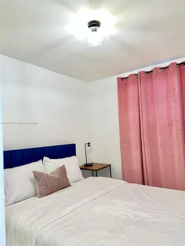 a bedroom with a bed and a mirror