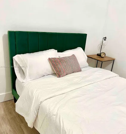 a bed sitting in a bedroom with large trees