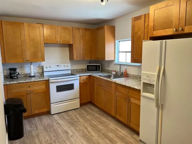 a kitchen with a white cabinets sink and white appliances