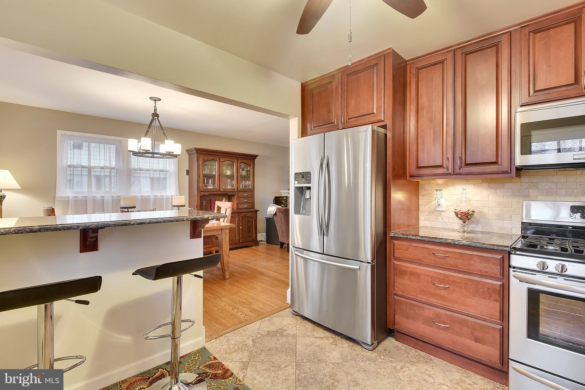 8108 Ellet Road Springfield, VA 22151 - Photo 5 of 21 a kitchen with granite countertop a refrigerator and a stove top oven