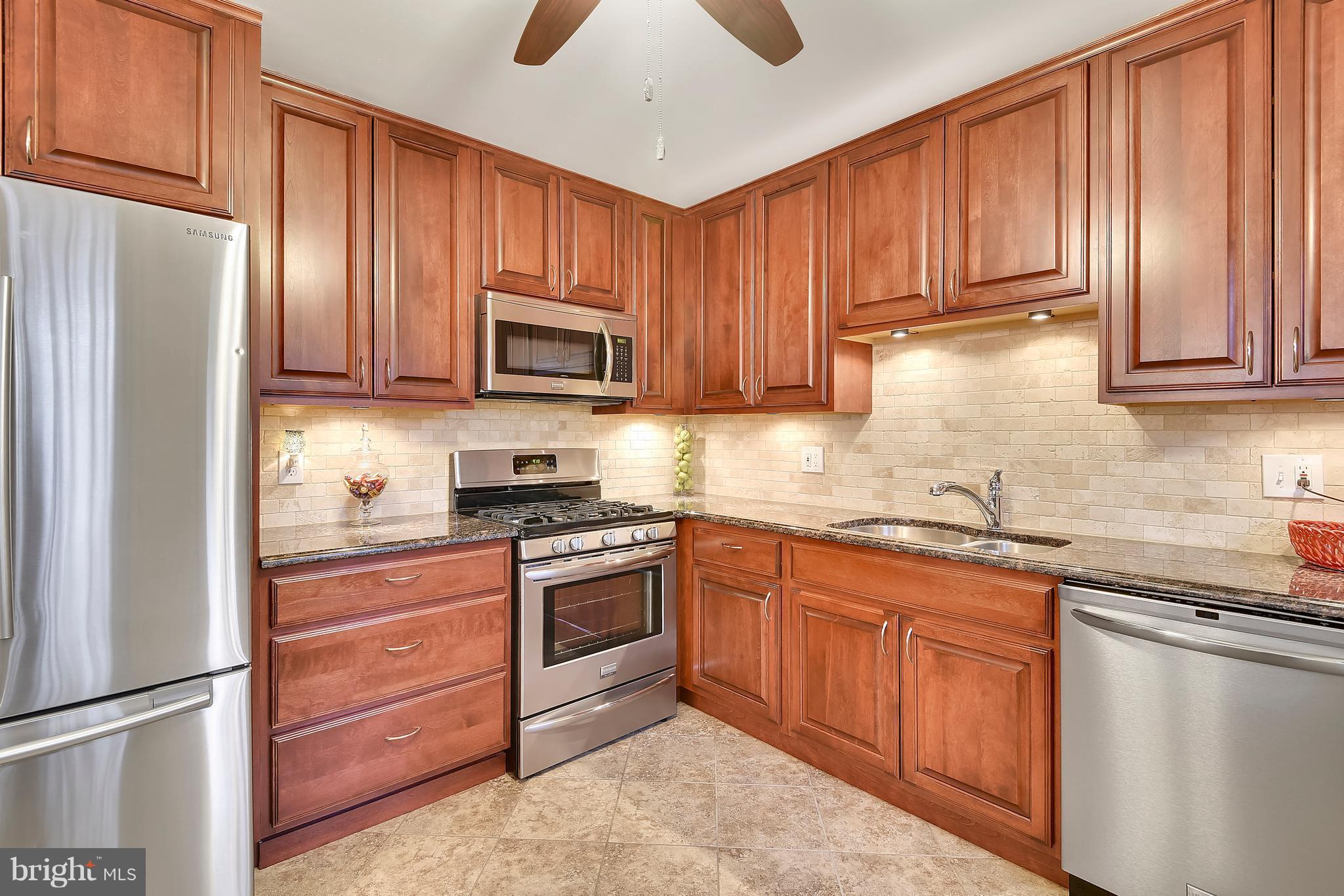 8108 Ellet Road Springfield, VA 22151 - Photo 6 of 21 a kitchen with granite countertop wooden cabinets stainless steel appliances and a window