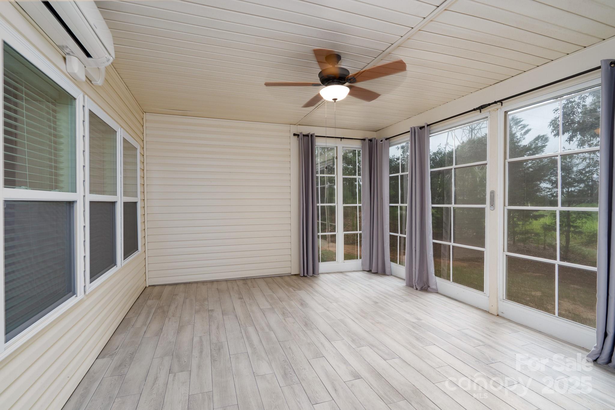 2496 Bergamot Street, Unit 61 Tega Cay, SC 29708 - Photo 33 of 43 a view of an empty room with a window and wooden floor