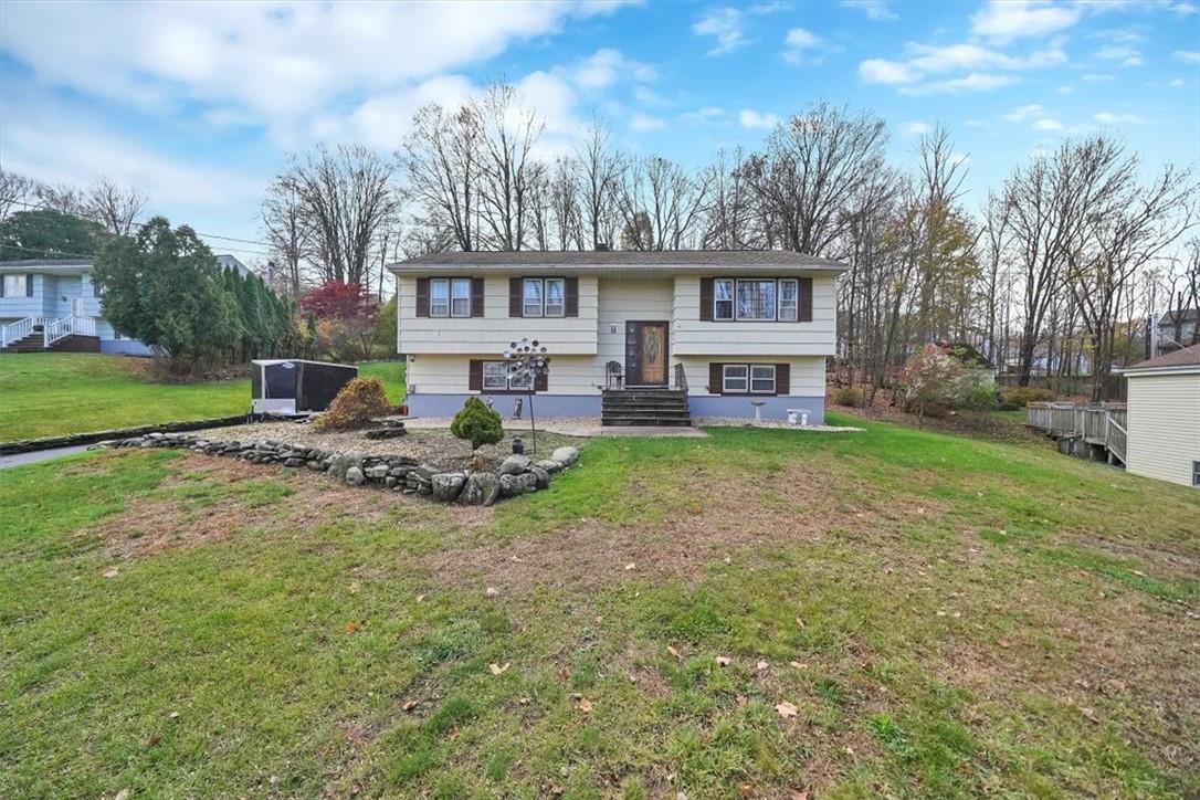 a view of a house with a yard and sitting area