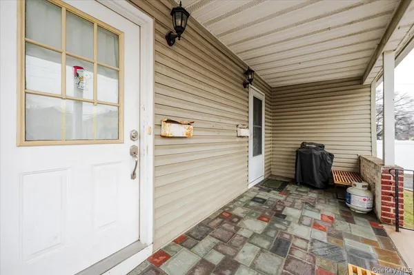 a view of a porch with a door and wooden floor
