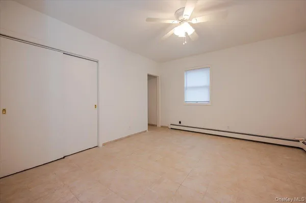an empty room with a ceiling fan and a window