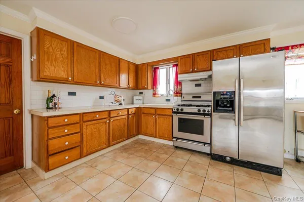 a kitchen with stainless steel appliances granite countertop a stove a sink and a refrigerator