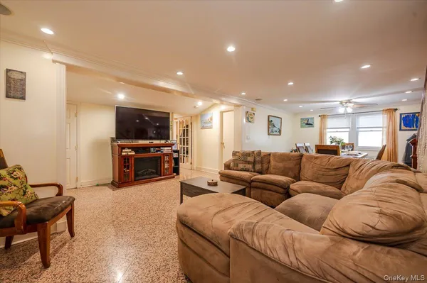 a living room with furniture kitchen view and a wooden floor