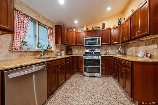 a kitchen with stainless steel appliances granite countertop a stove sink microwave and cabinets