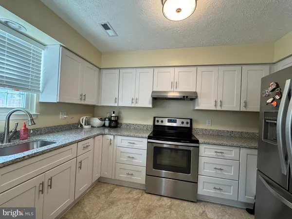 a kitchen with cabinets stainless steel appliances and sink