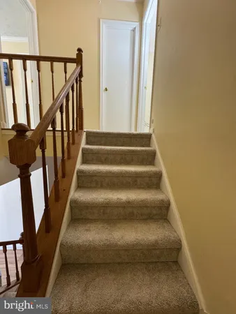 a view of staircase with lots of frames on wall