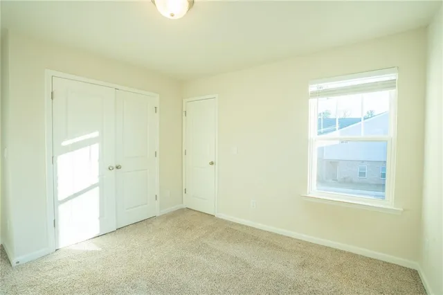 a bathroom with a toilet a sink a mirror a window and vanity