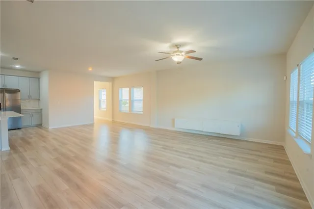 a view of empty room with wooden floor and windows