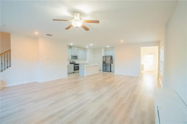 wooden floor in an empty room with a kitchen