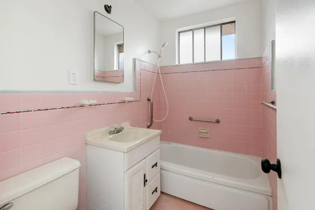 a bathroom with a sink toilet vanity and shower