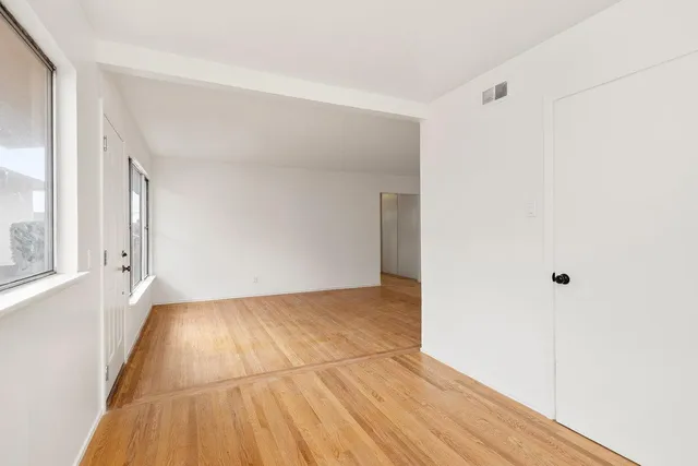 a view of an empty room with wooden floor