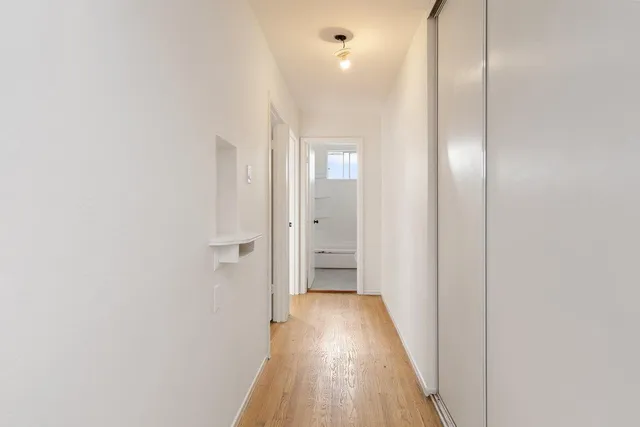 a view of a hallway with wooden floor