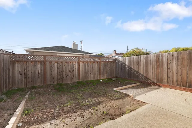 a view of a backyard with wooden fence