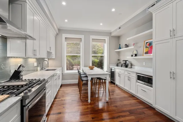 a kitchen with granite countertop white cabinets and white appliances