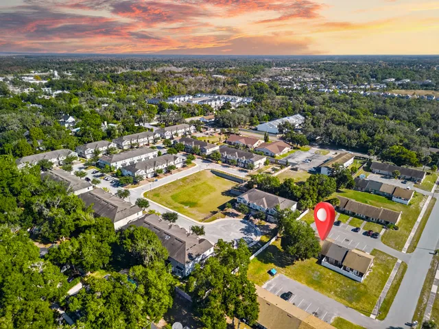 an aerial view of residential houses with outdoor space and parking