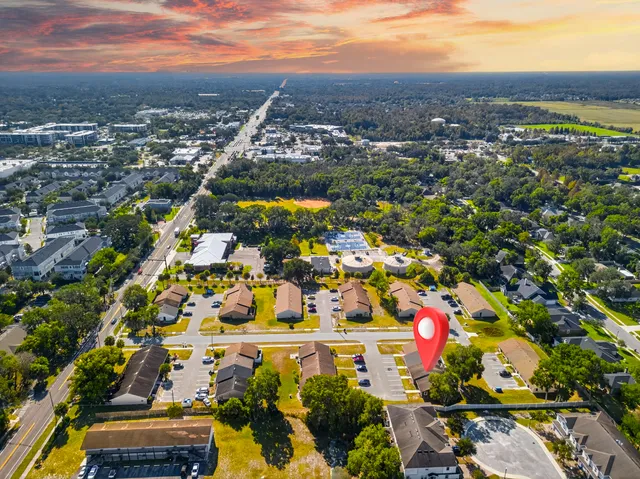 an aerial view of residential houses with outdoor space and trees