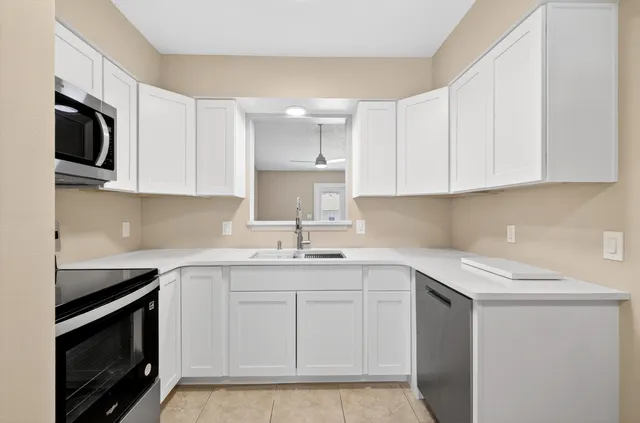 a kitchen with appliances a sink and cabinets