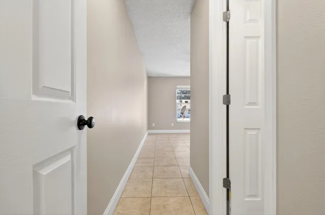 a view of a hallway with wooden floor and a bathroom