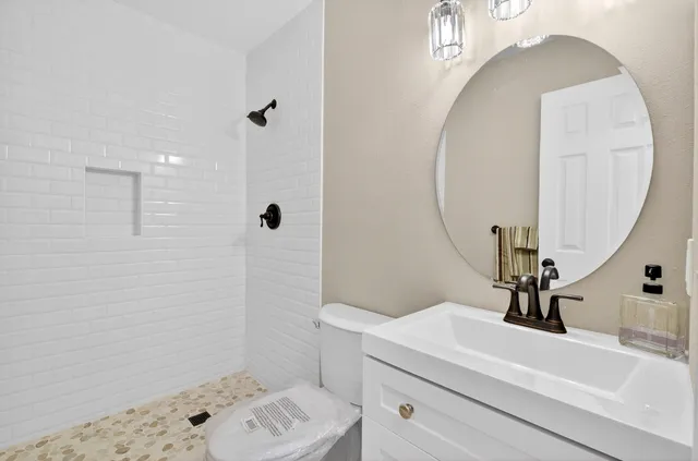 a bathroom with a sink a toilet and shower