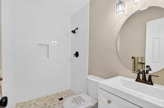 an empty room with windows and chandelier fan