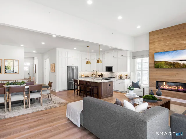a living room with furniture kitchen view and a fireplace
