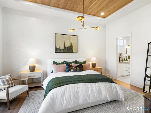 a bedroom with a bed couch and painting on the wall