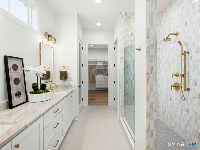 a bathroom with a double vanity sink a mirror a shower and vanity