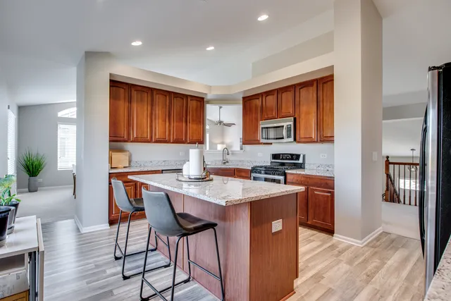 a kitchen with stainless steel appliances granite countertop a stove top oven a sink dishwasher and a refrigerator