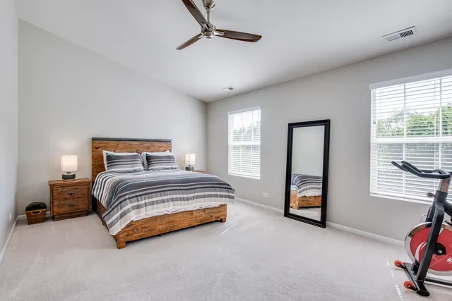 a bedroom with a bed a mirror and a window