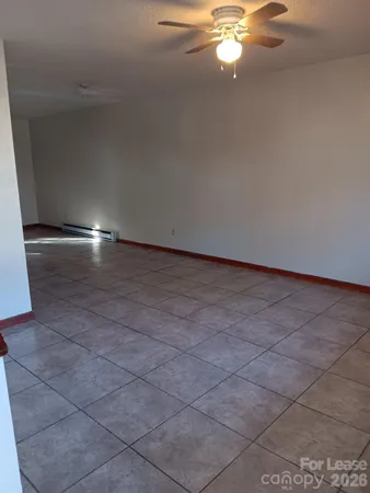 a view of an empty room with a chandelier fan