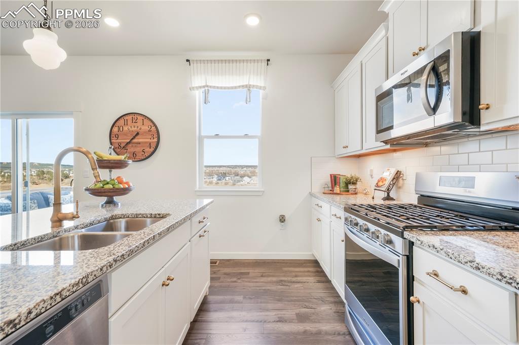 15882 Little Bluestem Road Monument, CO 80132 - Photo 12 of 50 Kitchen with gas range, stainless appliances, walk in pantry, granite countertops, large center island, under cabinet lighting