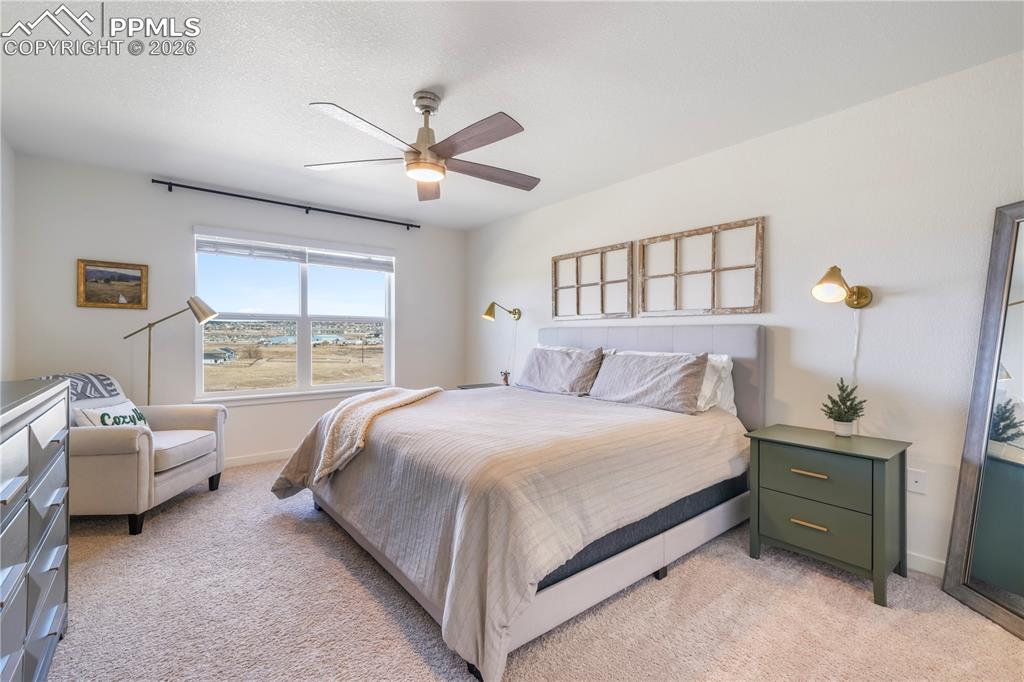 15882 Little Bluestem Road Monument, CO 80132 - Photo 22 of 50 Upstairs primary bedroom with space for seating area, ensuite bathroom and views