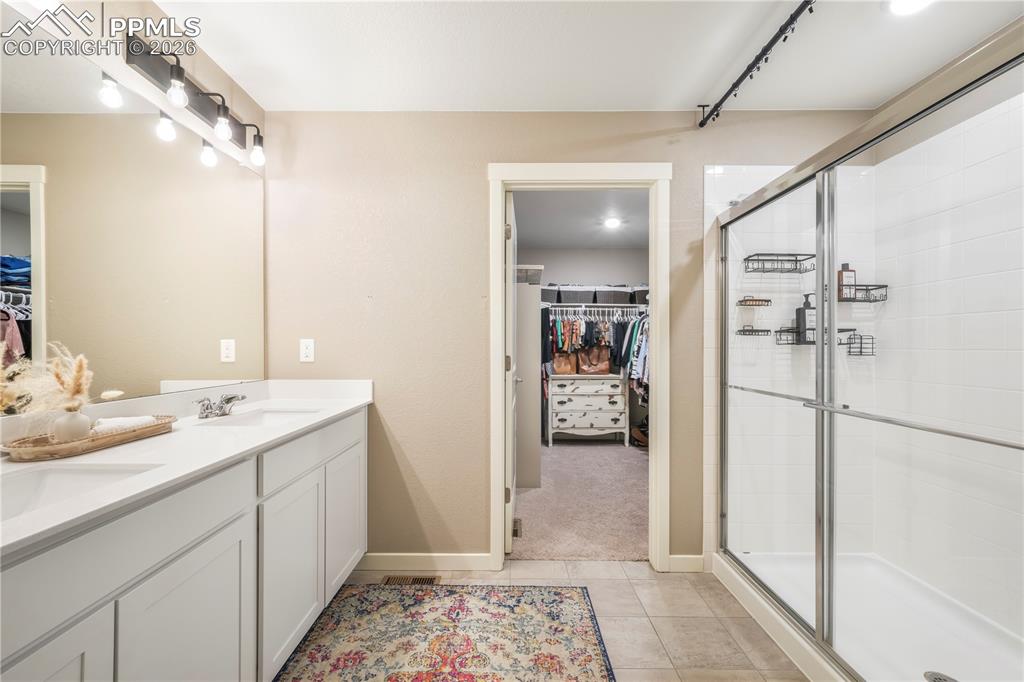 15882 Little Bluestem Road Monument, CO 80132 - Photo 25 of 50 Primary bath with dual vanities, quartz counters, large walk in shower, separate water closet, linen closet and large walk in closet