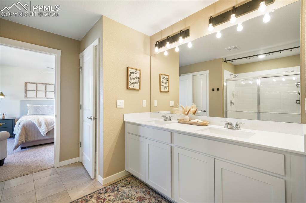 15882 Little Bluestem Road Monument, CO 80132 - Photo 26 of 50 Primary bath with dual vanities, quartz counters, large walk in shower, separate water closet, linen closet and large walk in closet