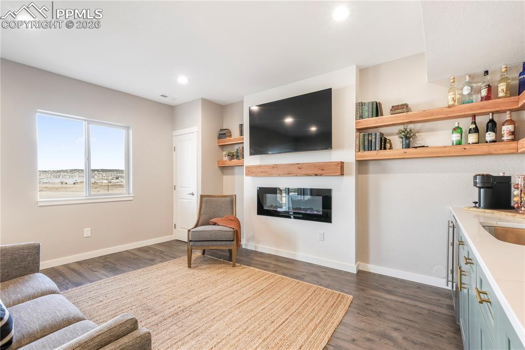 15882 Little Bluestem Road Monument, CO 80132 - Photo 37 of 50 Walk out basement family room with electric fireplace and wet bar with quartz counters