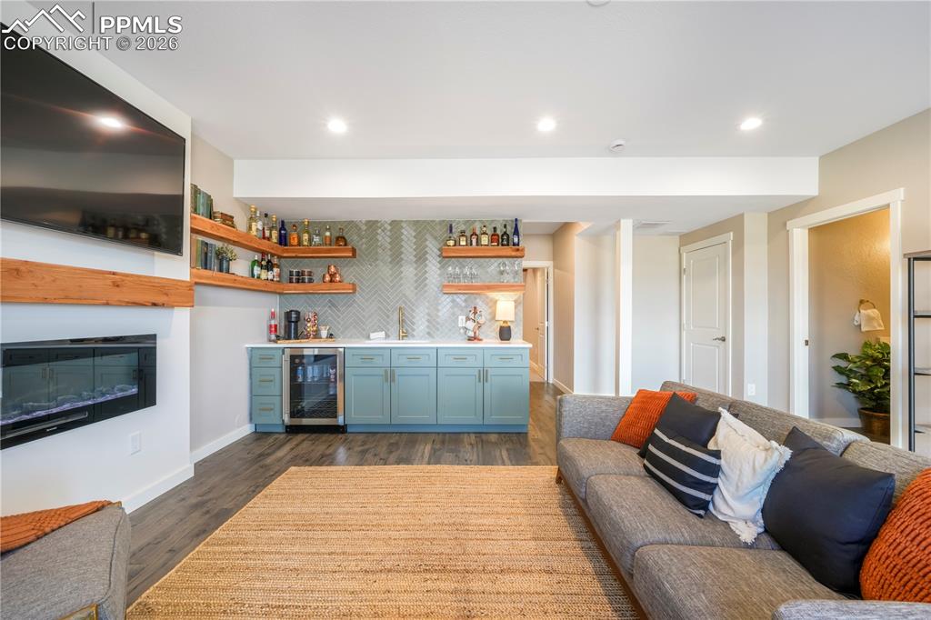 15882 Little Bluestem Road Monument, CO 80132 - Photo 38 of 50 Walk out basement family room with electric fireplace and wet bar with quartz counters