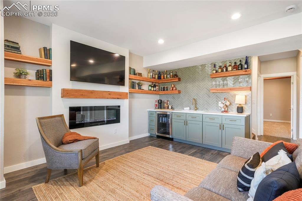 15882 Little Bluestem Road Monument, CO 80132 - Photo 39 of 50 Walk out basement family room with electric fireplace and wet bar with quartz counters