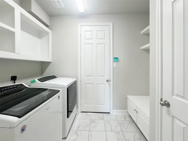 a utility room with cabinets washer and dryer