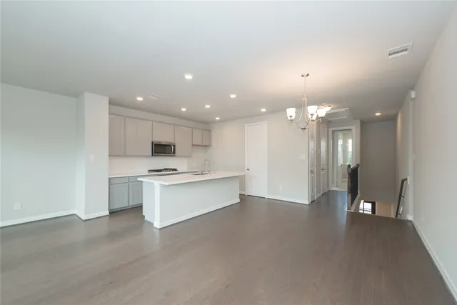 a large kitchen with a refrigerator a sink dishwasher and a fireplace with wooden floor